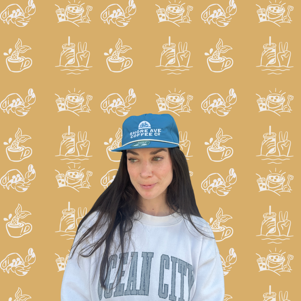 Person wearing a blue cap and light blue sweatshirt with text on a patterned background